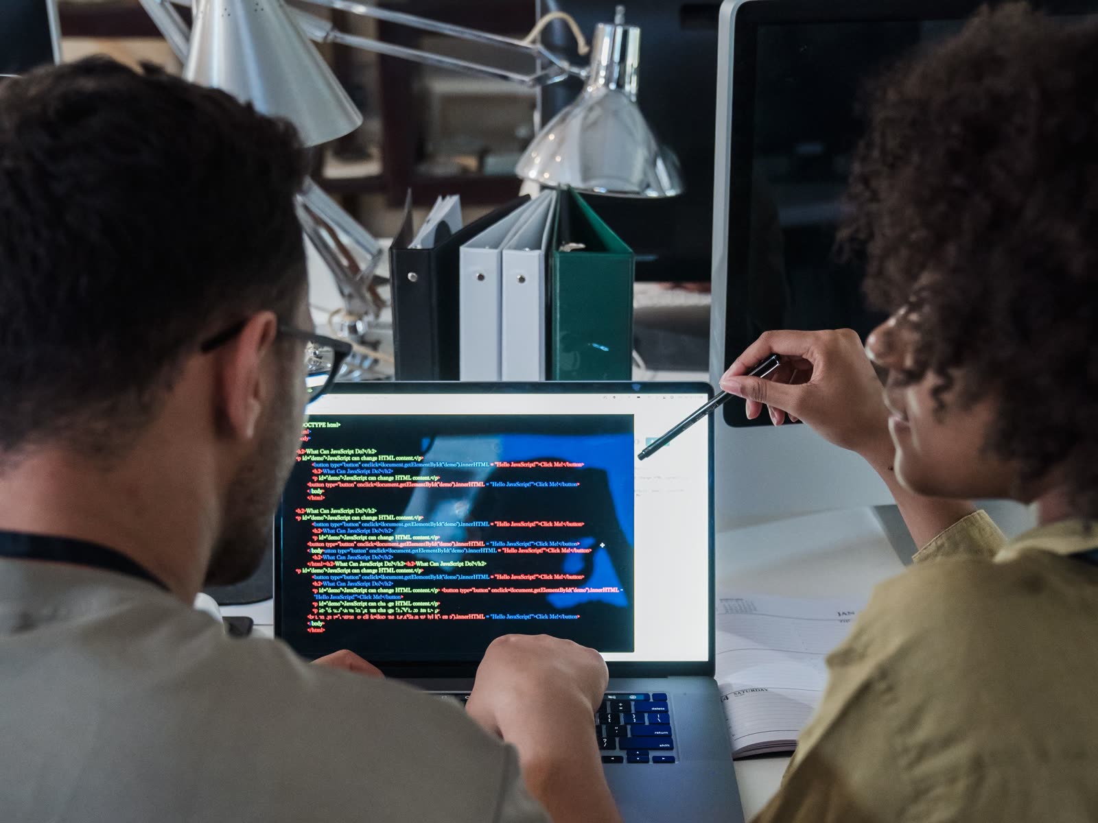 Two developers work together at a laptop.