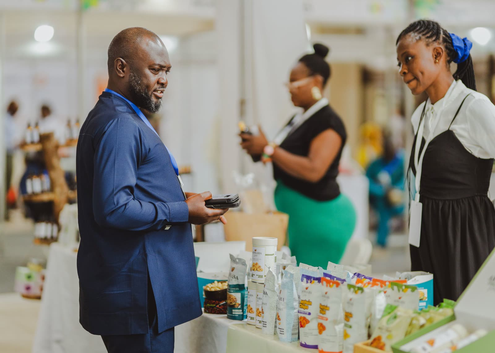 Business people talk at a trade-show stand.
